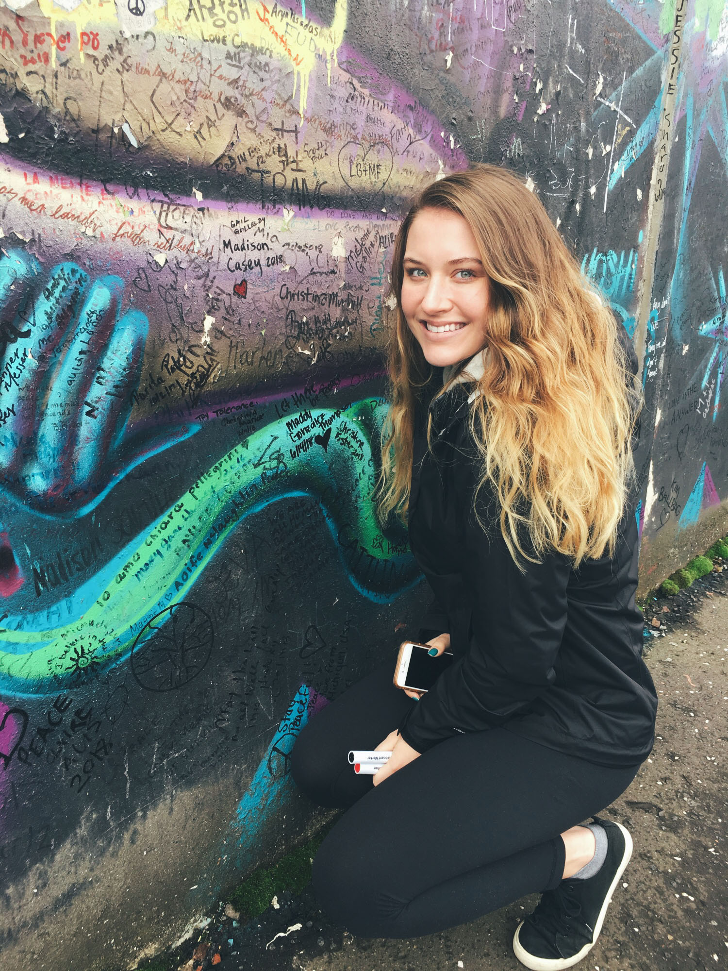 girl stands in front of painted wall