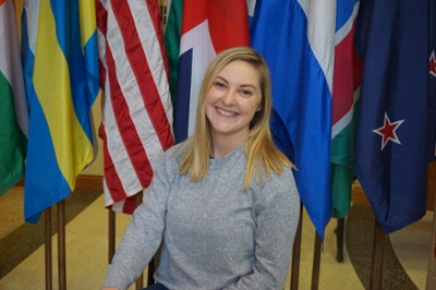 macy poses in front of flags