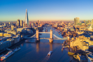 the london skyline next to the river thames and tower bridge