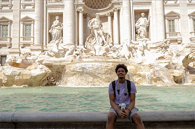 Kyle poses in front of a fountain