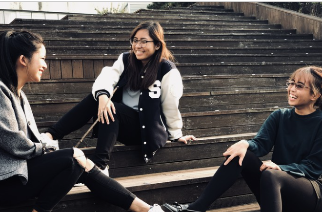Smiling students recline on steps