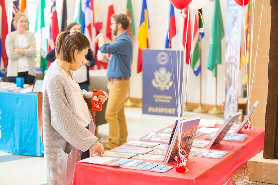 a woman viewing materials at a table during a study abroad fair