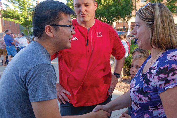 International student meeting other students and community members at Miami and shaking hands