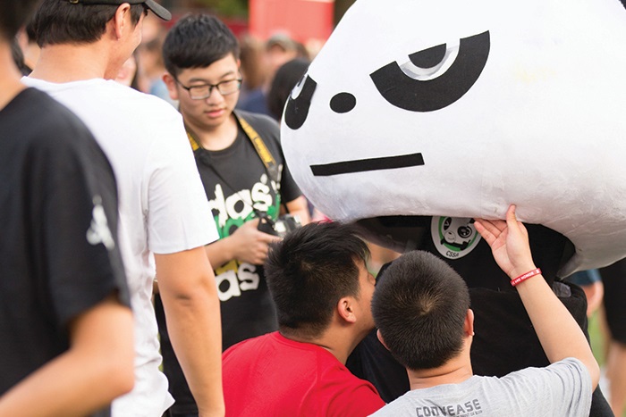 Student inspect a panda bear mascot costume