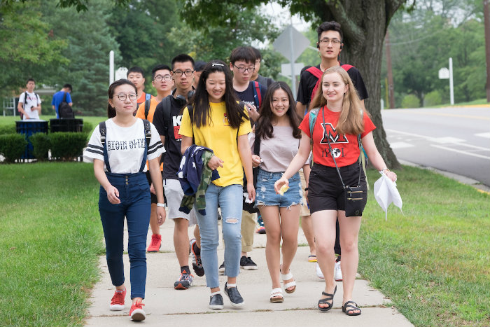 A group of international students walking across the Oxford campus