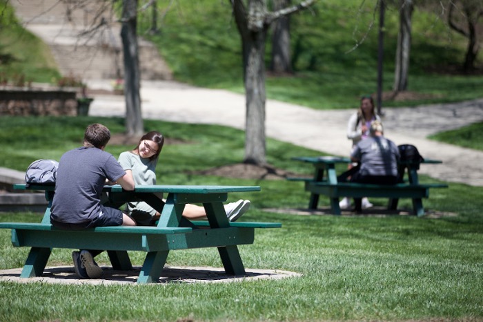Students chat at picnic tables on a regionals campus