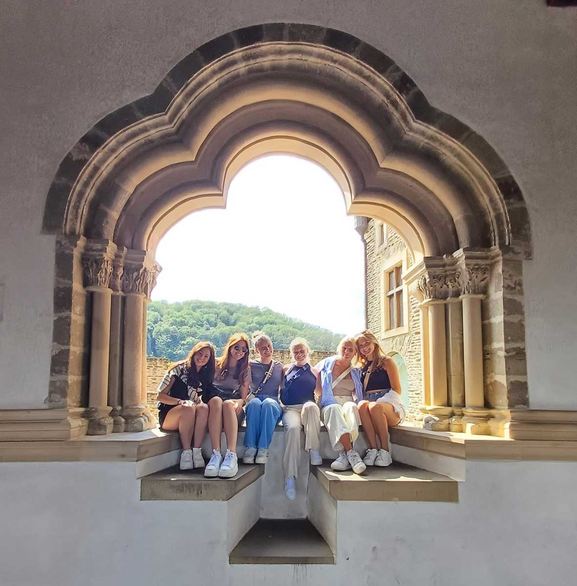 students seated in a large window opening
