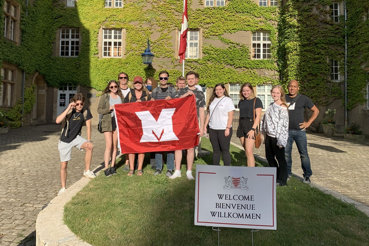 A group of study abroad students posing outside of the Chateau in Luxembourg