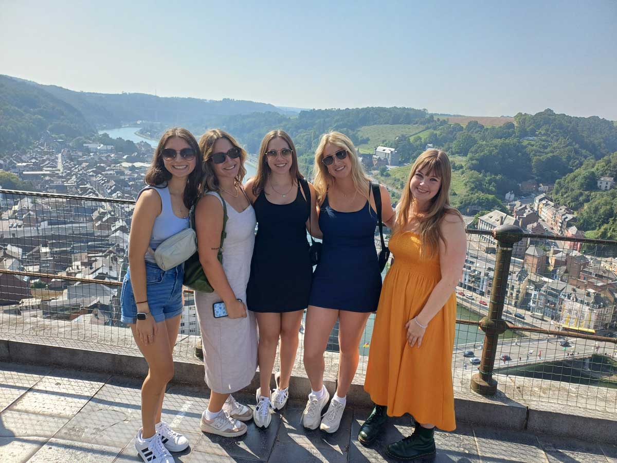 students standing at an observation point overlooking a European city