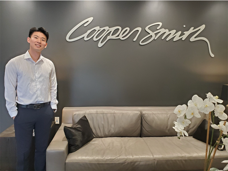 James in front of Cooper Smith sign