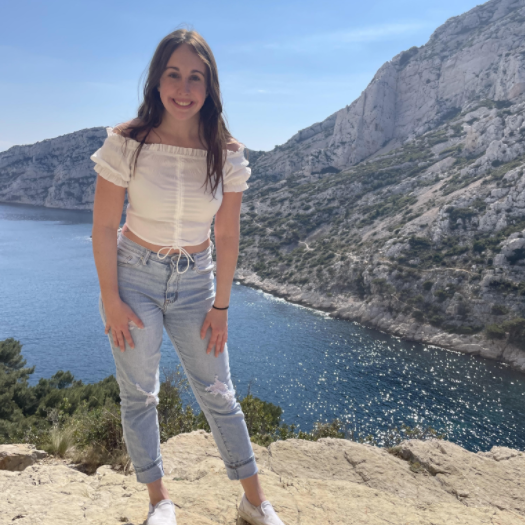 Angel stands in front of the sea during her study abroad in Europe