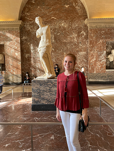 Grace poses near a statue