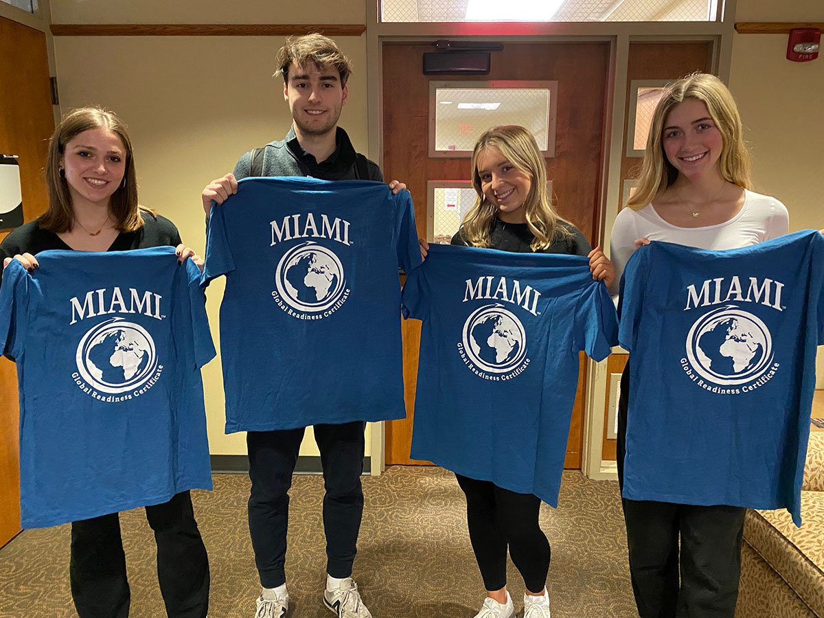 Four CCA students hold their tshirts out for the camera