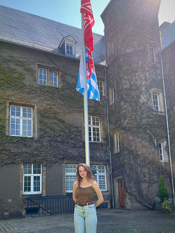 Corbett poses near the flagpole outside of the Château