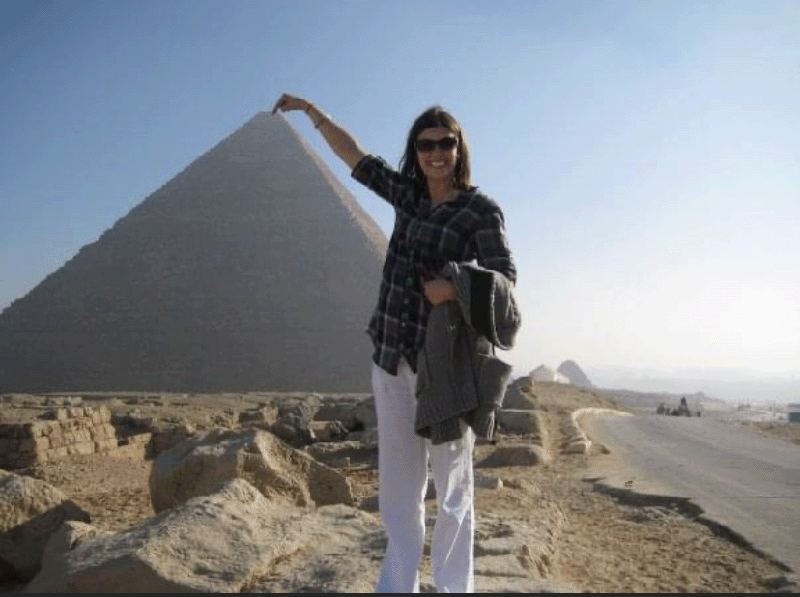 Miller comically poses as though she is touching the top of the pyramid