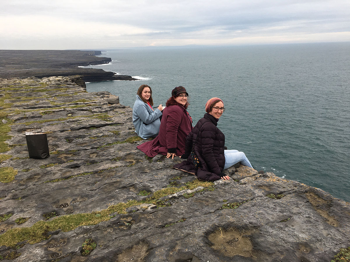 Students sit at the shore of the lake