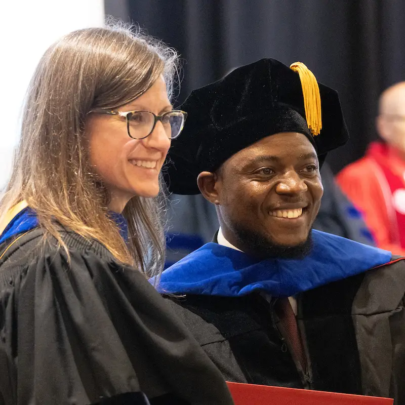 graduate student with professor smiling for photo