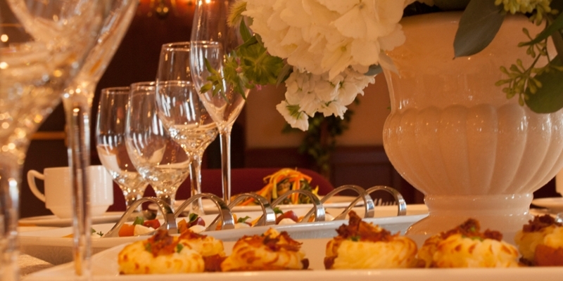 A table set with food and wine glasses.
