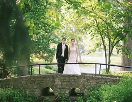 A bride and groom on the bridge near the Conrad Formal Gardens.