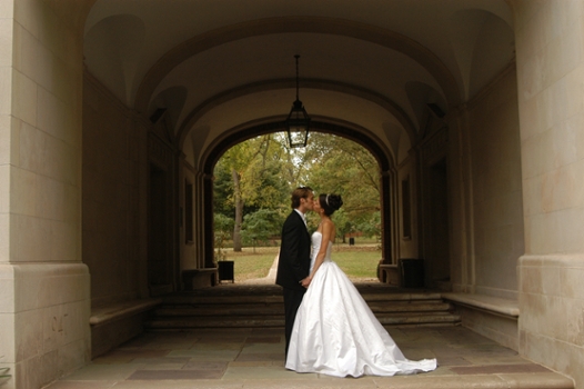A bride and groom kiss under the Upham Arch.