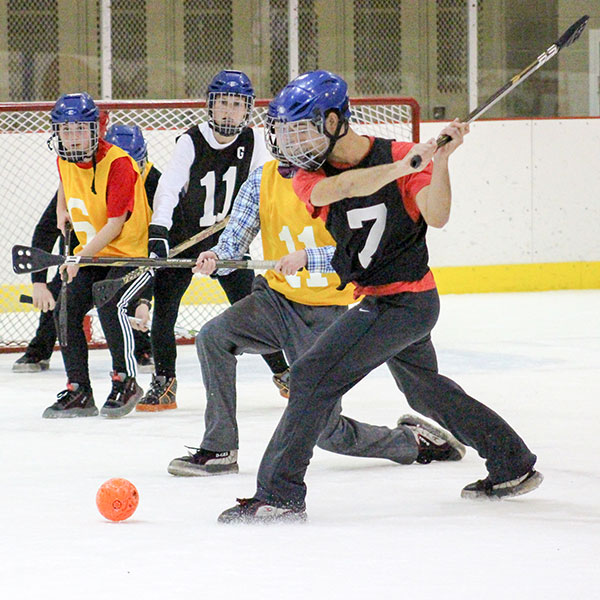 Student shooting a goal in broomball