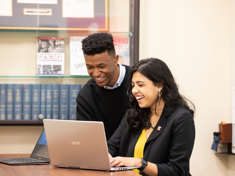 A student working with his advisor at a computer.