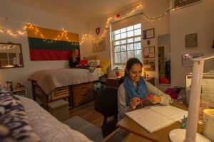 a student working on a laptop in a dorm room