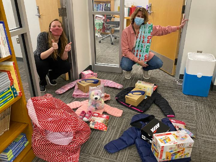 Mandy Olejnik, Assistant Director of Writing Across the Curriculum, and Loretta Parker, Administrative Assistant for the Howe Center for Writing Excellence, wrapping gifts for the sponsored children.
