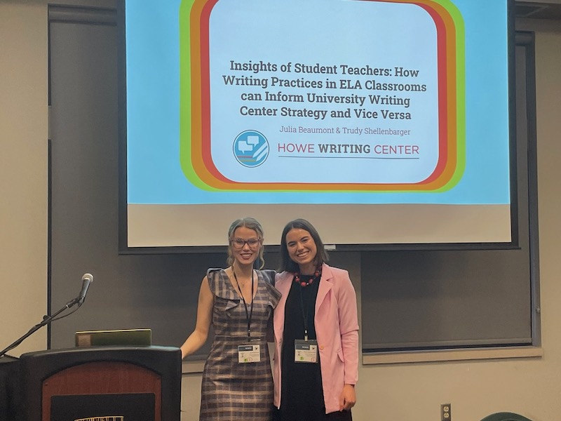 Two consultants standing in front of a screen with their presentation title: "Insights of Student Teachers: How Writing Practices in ELA Classrooms can Inform University Writing Center Strategy and Vice Versa" 