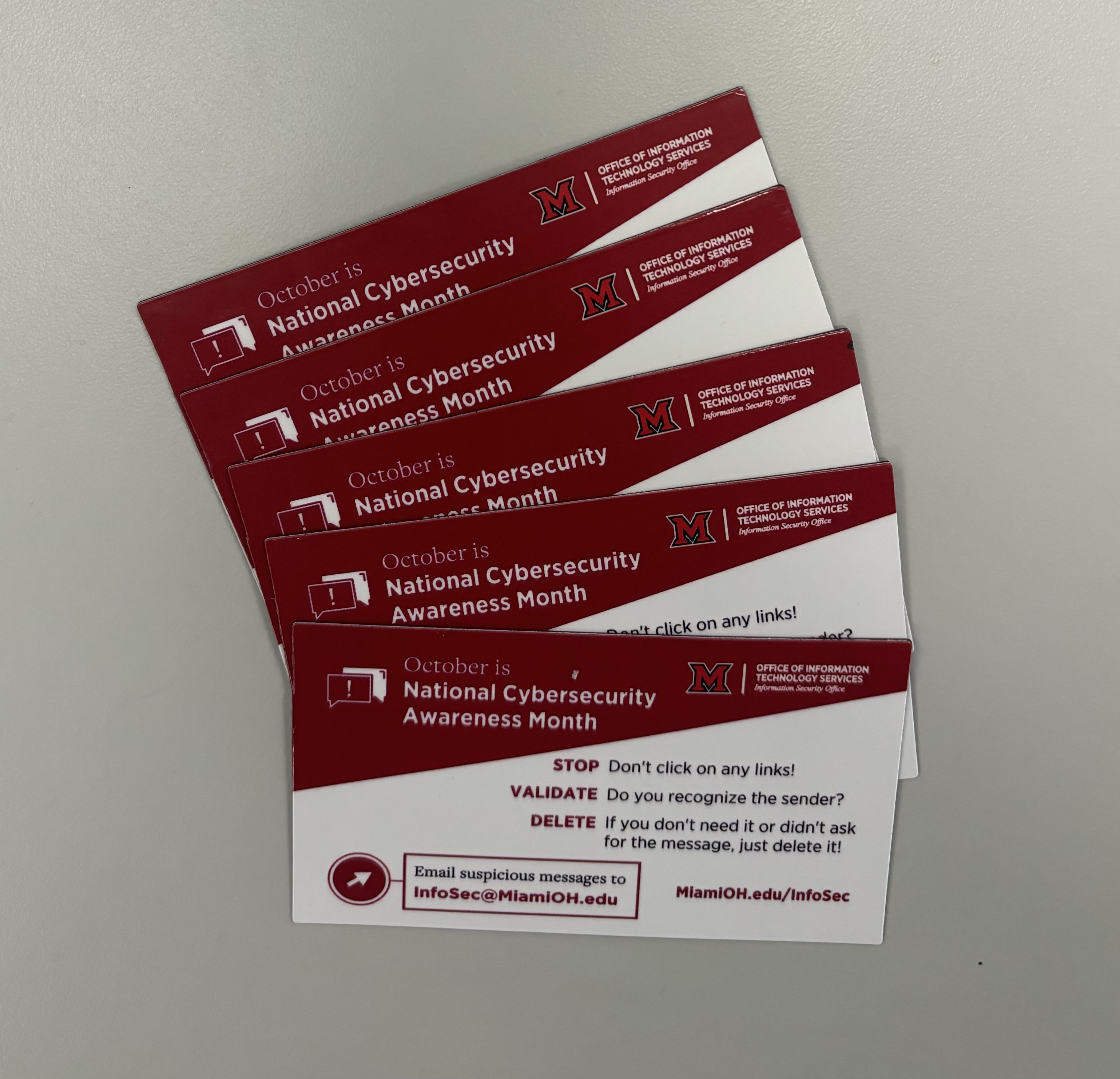A stack of business-card-sized magnets with STOP VALIDATE DELETE and info about National Cybersecurity Awareness Month