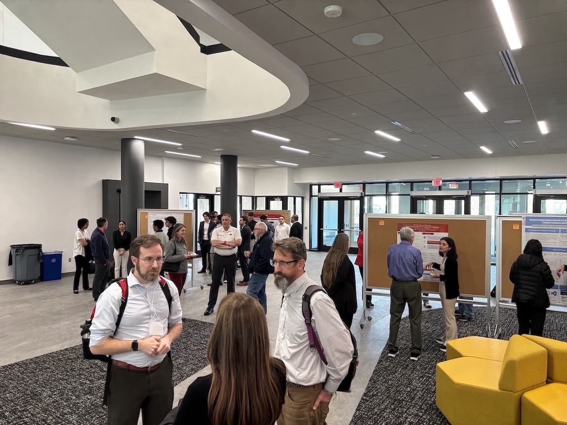 A group of attendees at the 2025 Miami IA Symposium poster session in the McVey Data Science Building
