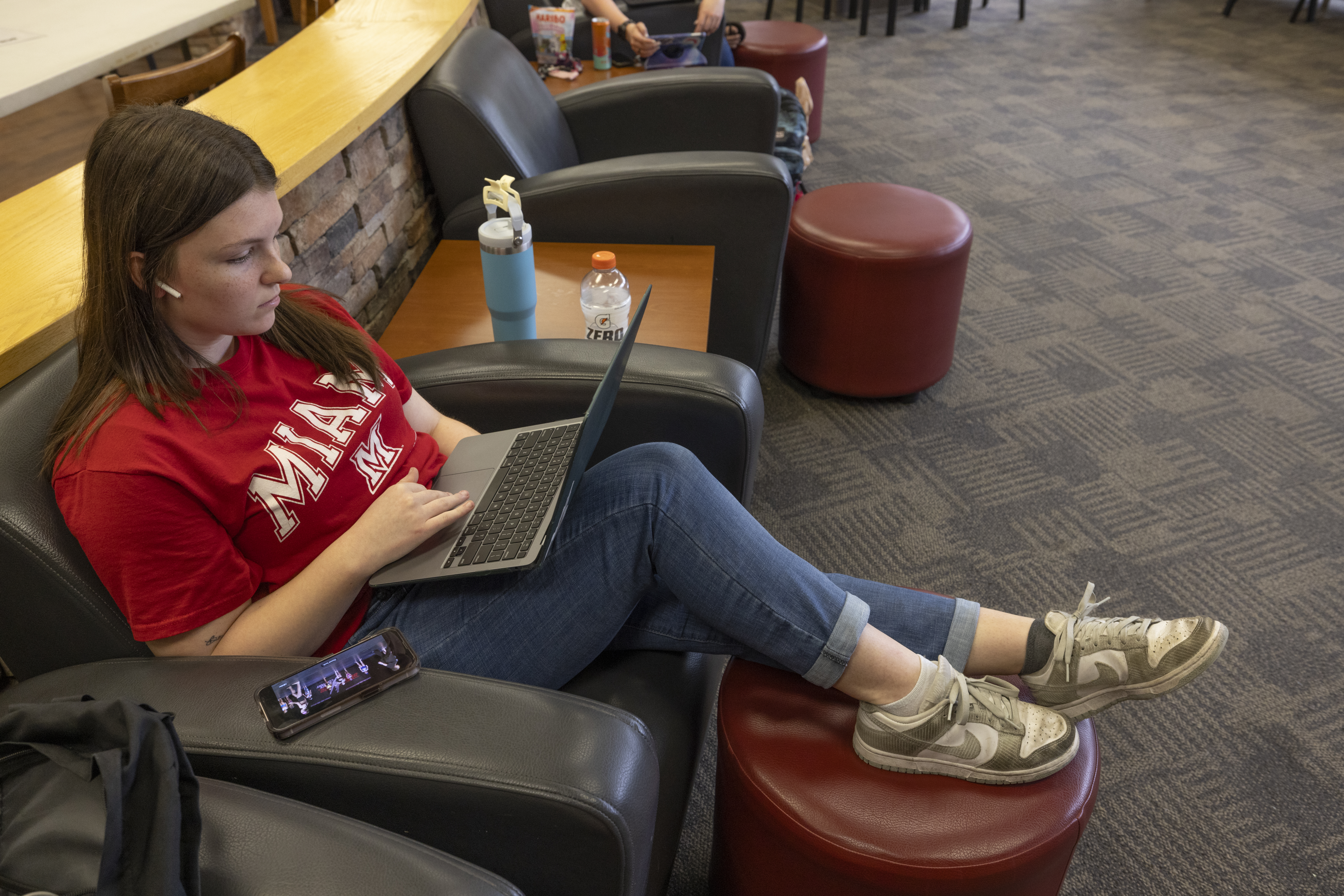 Student reclining in a chair with laptop on their lap