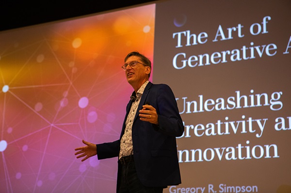 Gregory Simpson, keynote at the first Miami AI Symposium, stands in front of a presentation labeled the Art of Generative AI