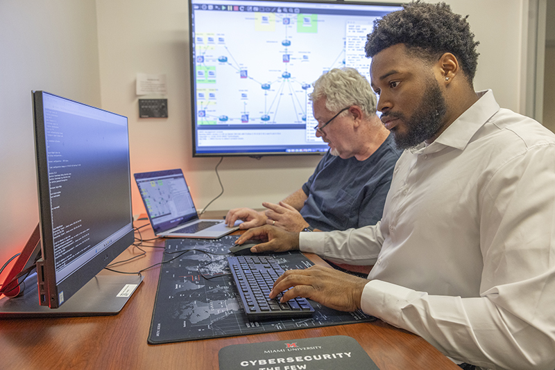 Two people sit at a desk working