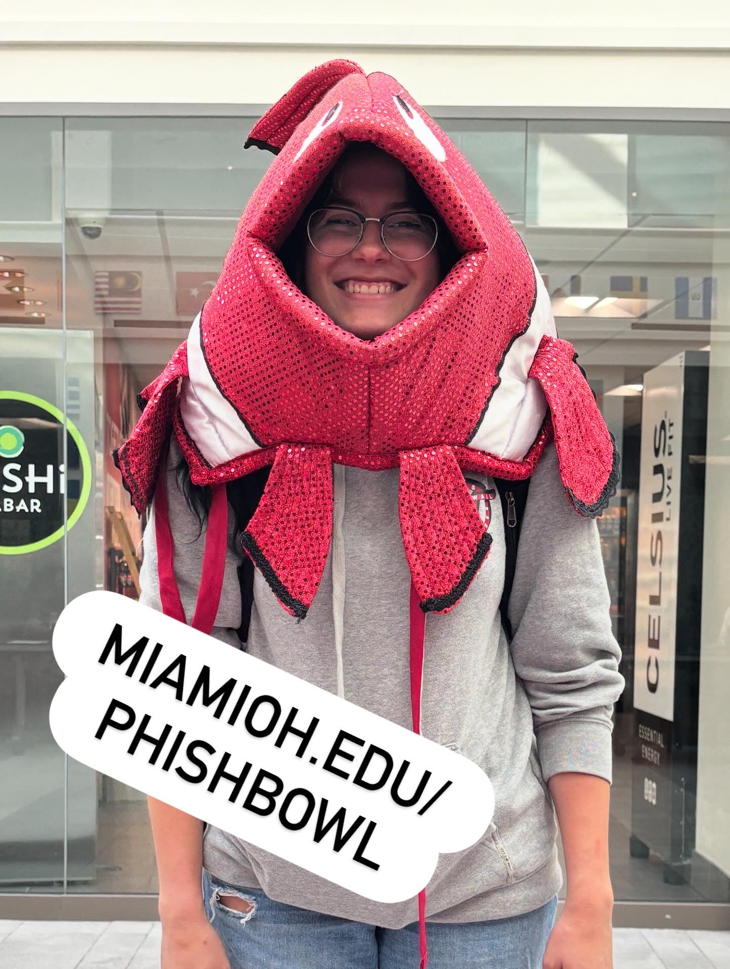 A smiling student wearing a red costume cloth fish head ('phish')