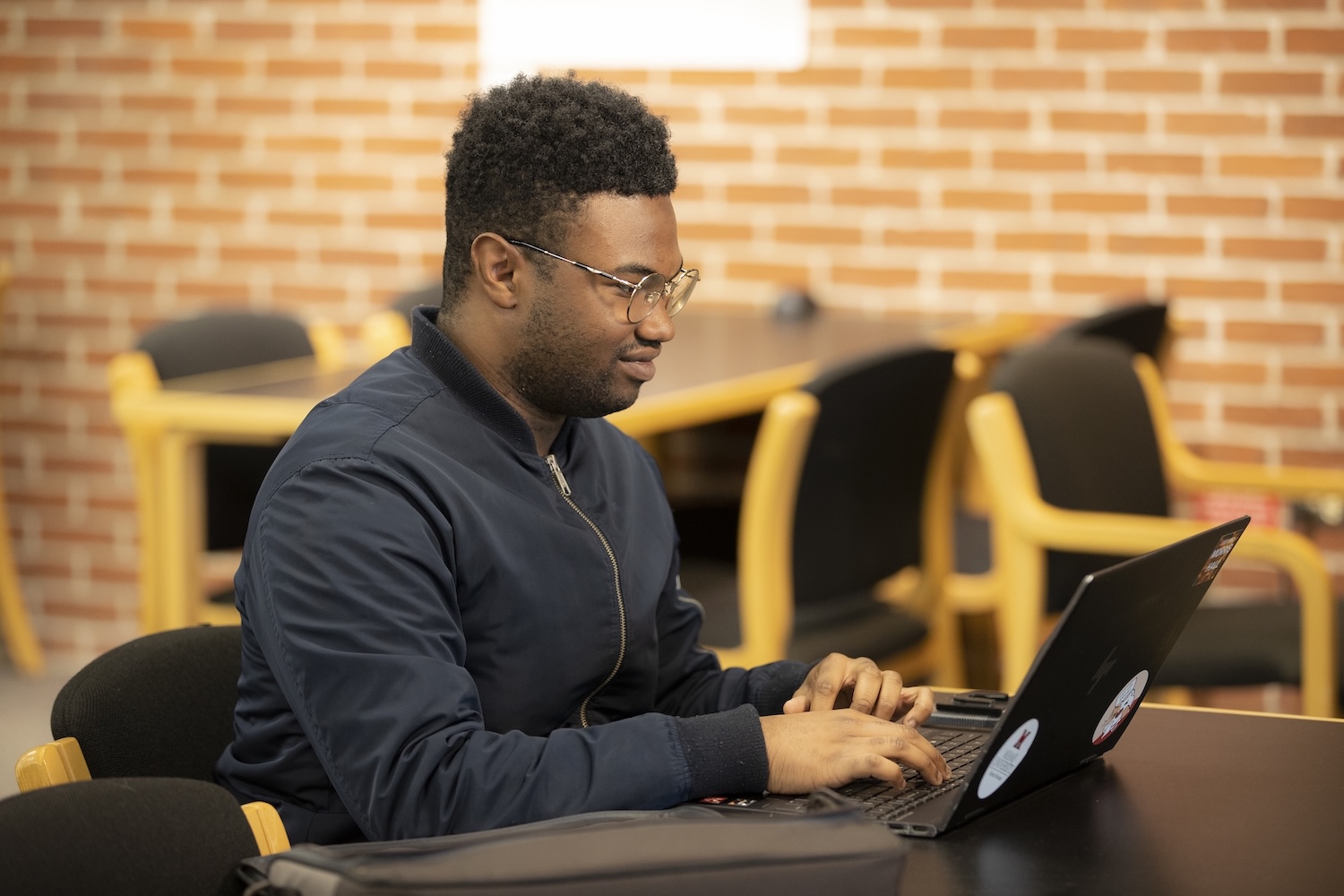 Student working on their laptop at a table