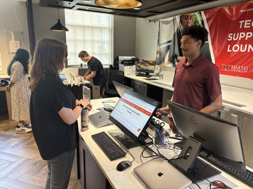 Skylar Hamilton helping a student at the tech support lounge
