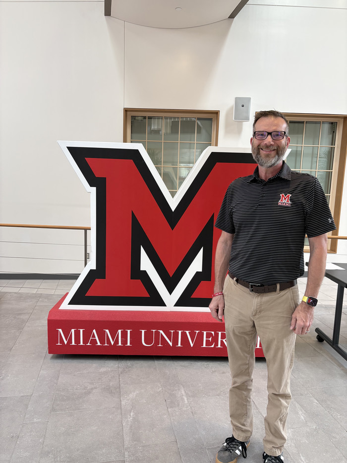 Craig Martin stands next to the Miami M