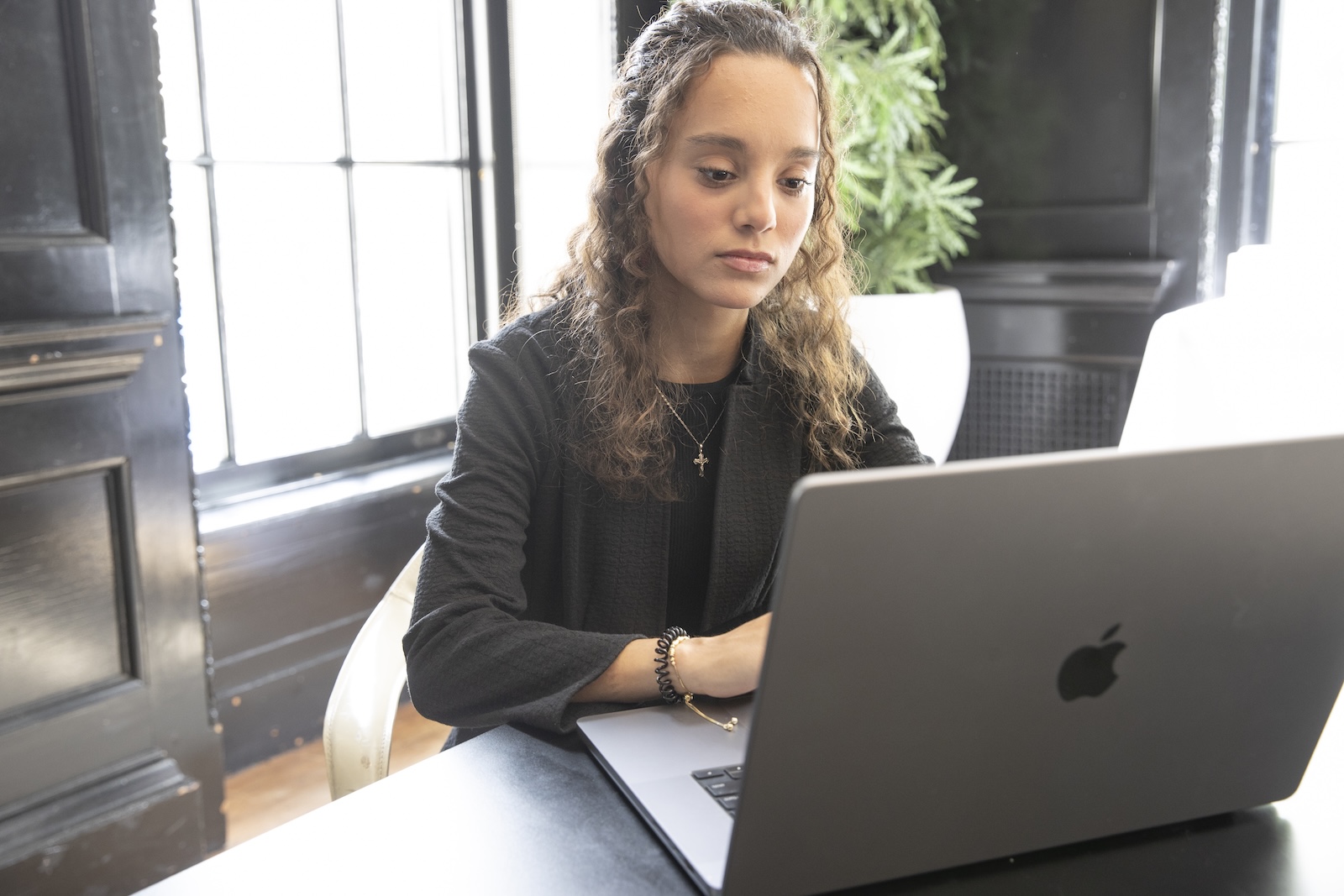 A student sitting at a desk working on her laptop