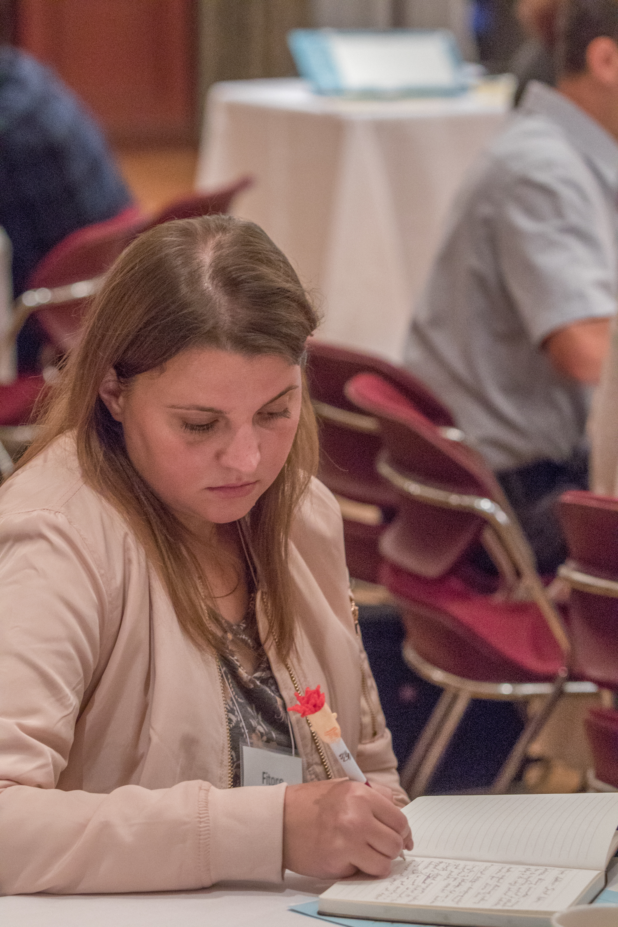 A crowd of attendees take notes during the keynote address.