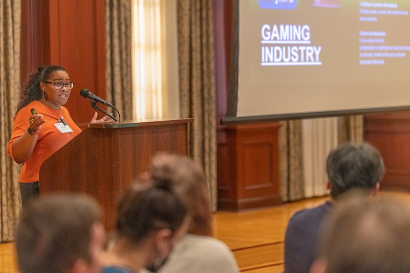 Belinda speaks next to the screen which displays partial view of gaming slide