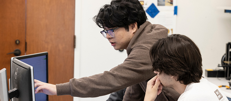 Student employees collaborating on a computer
