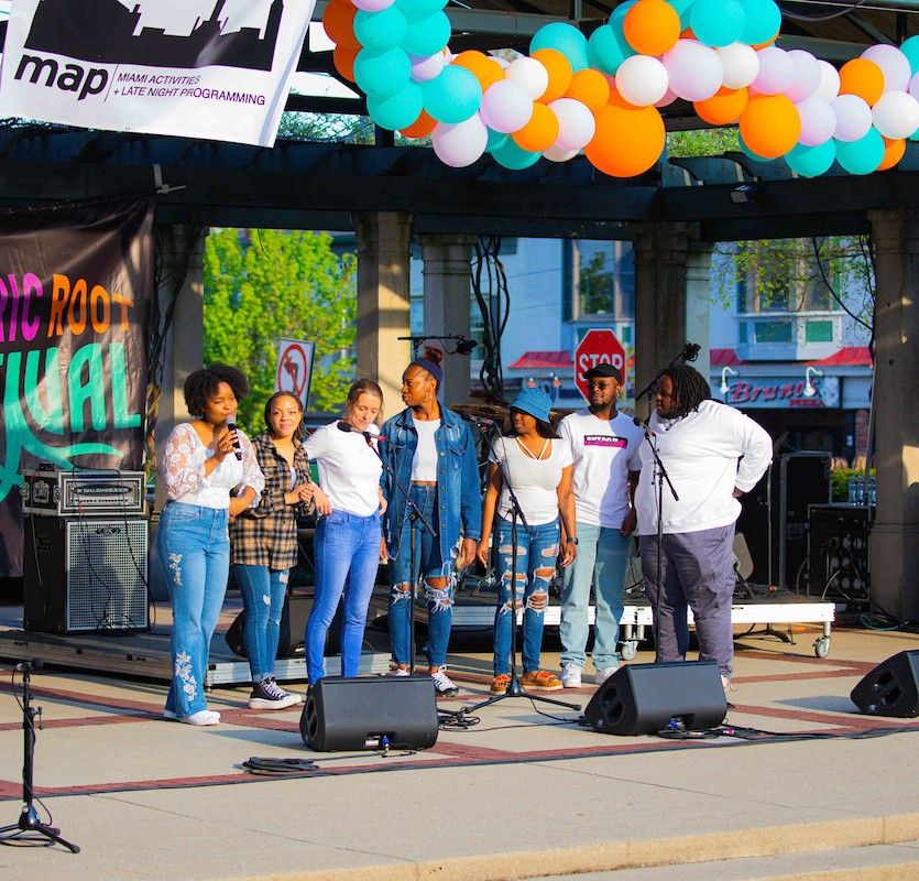 A group of singers perform on stage in Uptown Oxford, Ohio at the annual Electric Root Festival