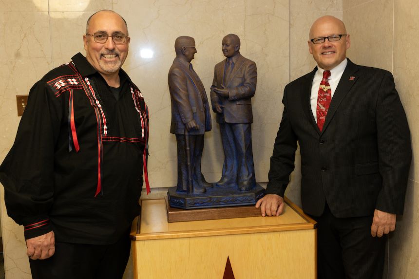Miami Tribe of Oklahoma Chief Douglas Lankford and Miami University President Gregory Crawford smile for the camera next to a sculpture.