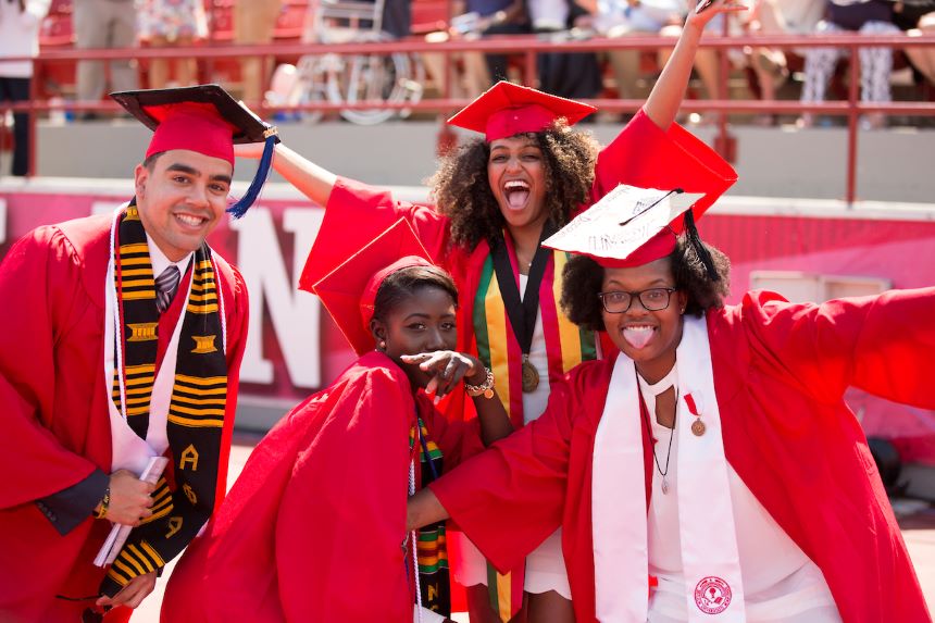Four students celebrate at graduation.