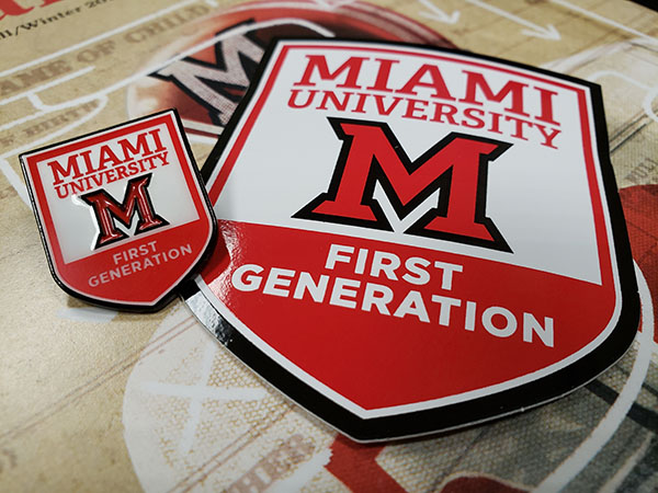 Stickers and pins saying Miami University First Generation