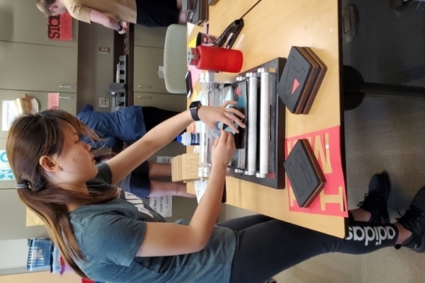 An RA working in the RA Resource Room on a die cut machine