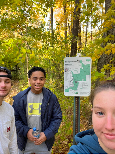 students taking a selfie in front of a map of the natural areas