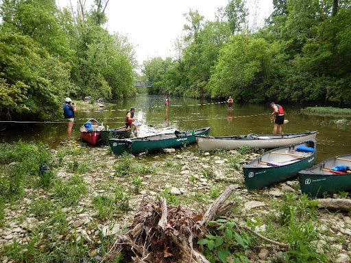 students in canoes on the shore of a river
