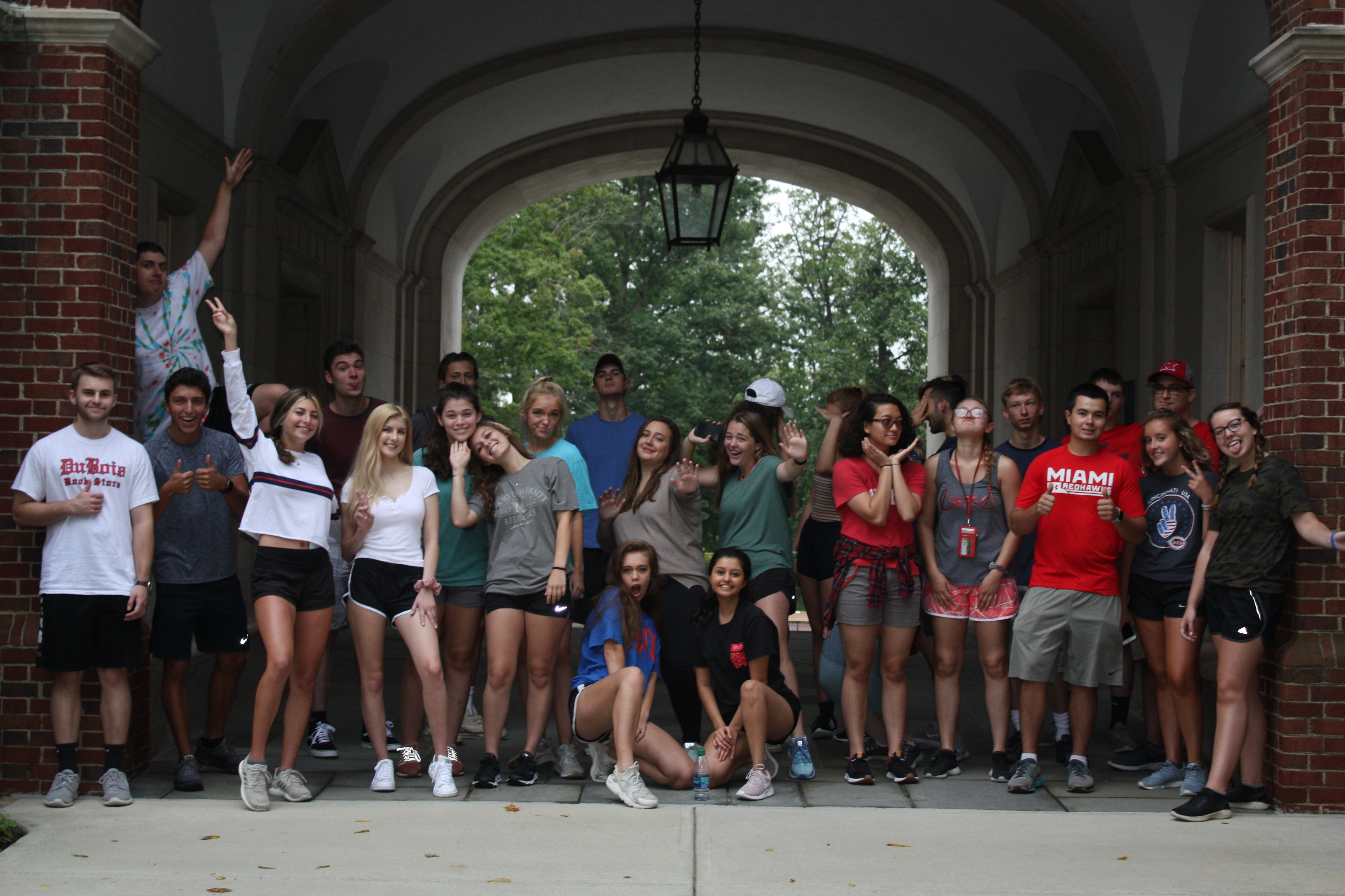 Group of about 30 students posing under the upham arch